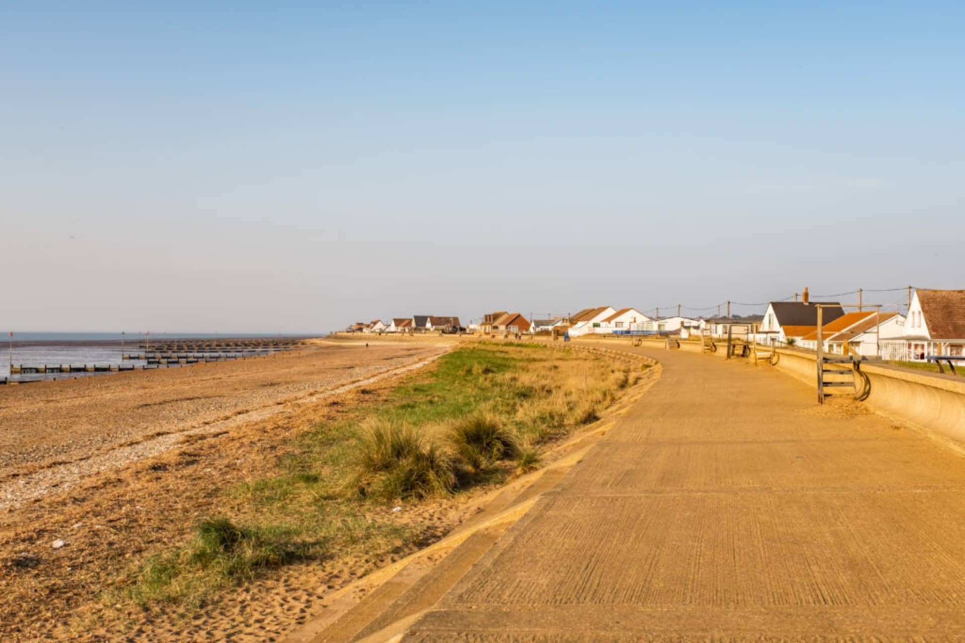 Heacham beach esplanade, with the beach and houses in the background, North Norfolk coast, in the late afternoon as the sun starts to set