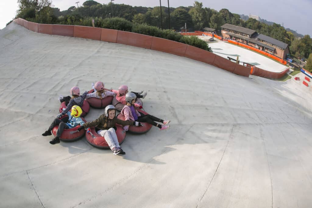 A group of people in rubber rings ready to do a tubing activity down an ice slope in Norfolk.