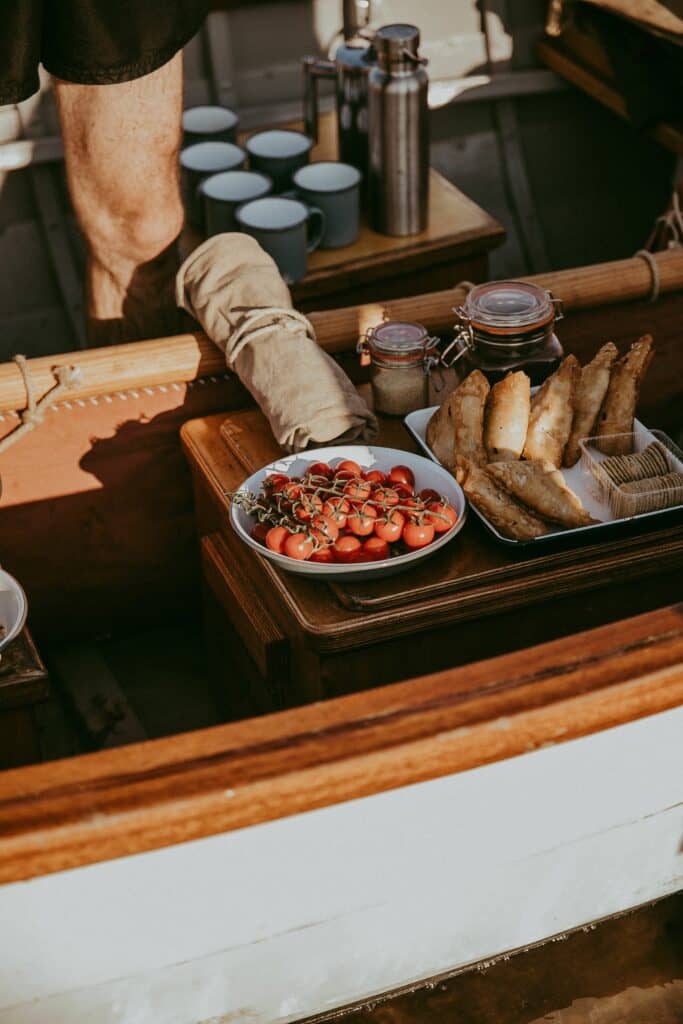 A plater of food and drinks on a boat for sailers to enjoy.