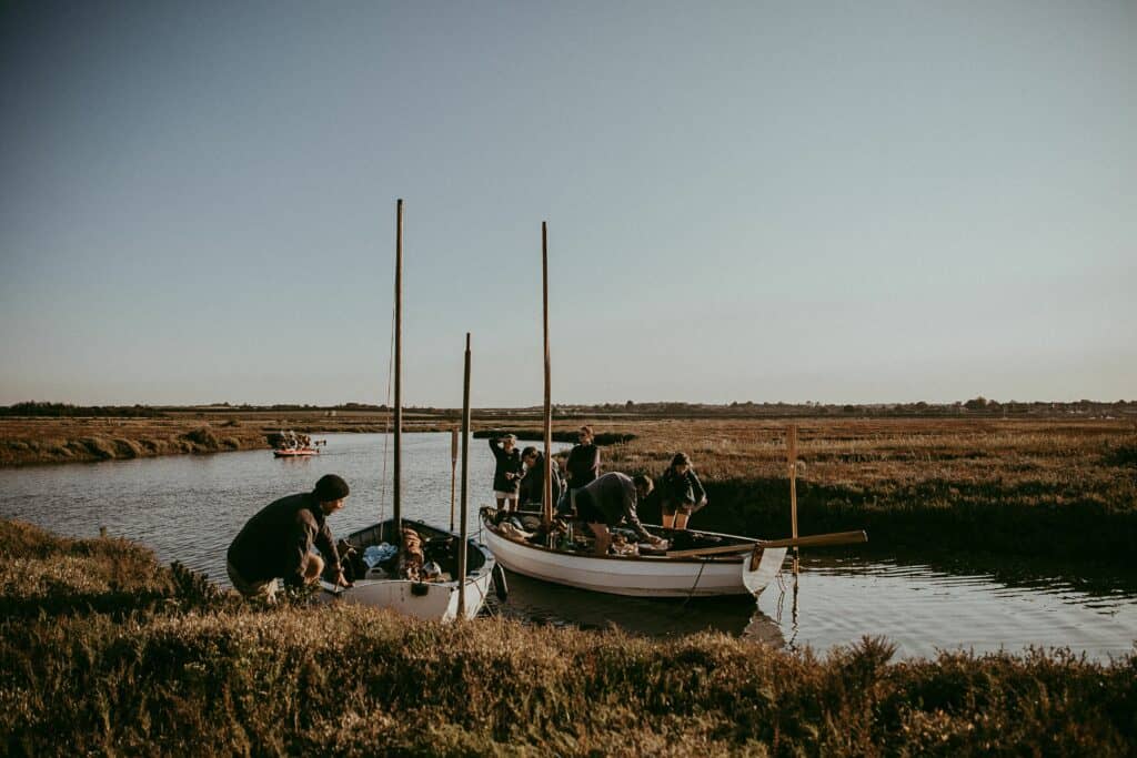 A group of people load up two boats ready to sail down the Norfolk Borads.