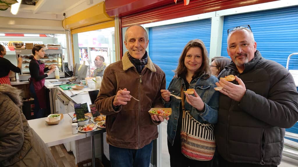 A group of people posing with food at Norwich market.