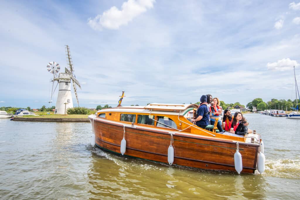 Moorhen Cruiser on river in front of windmill