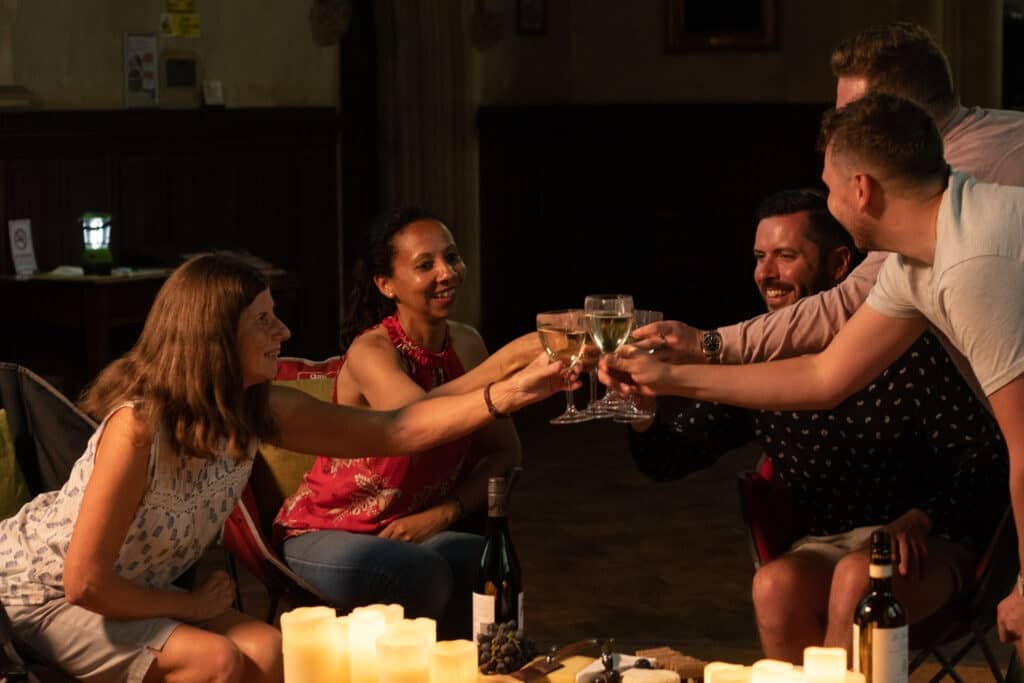 Five people toast a glass of wine