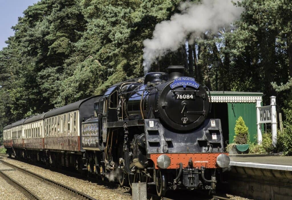 A steam train going down the track in Norfolk.