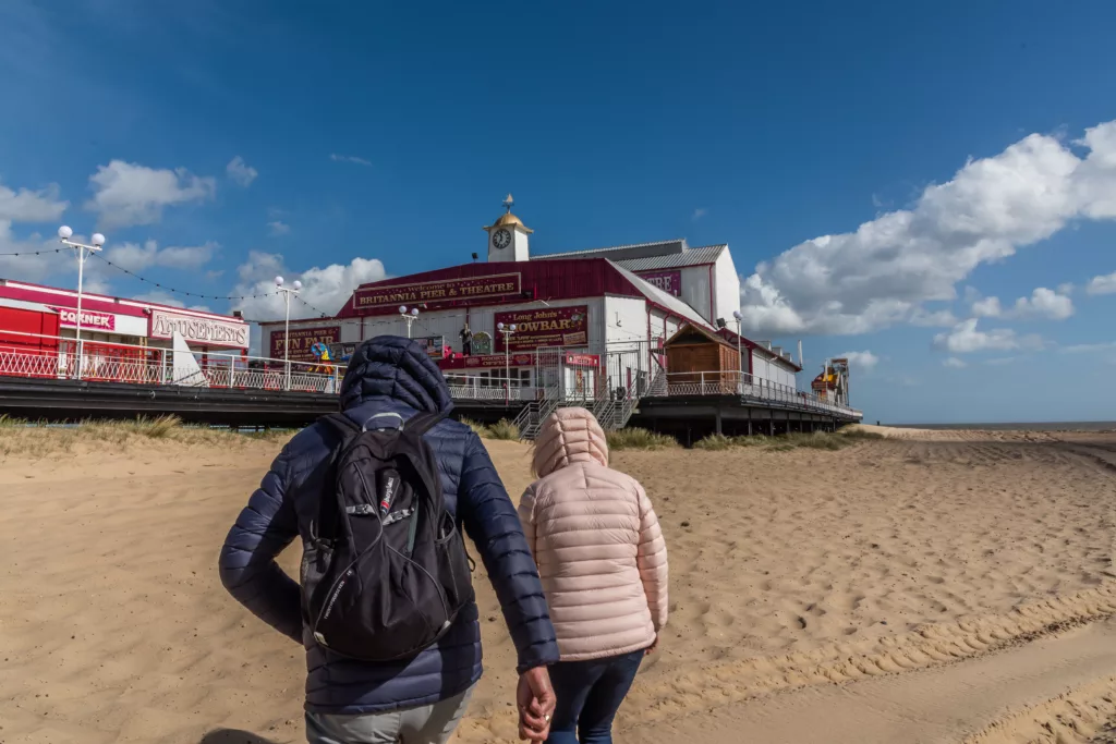 Two people walking towards Britannia Pier, Great Yarmouth