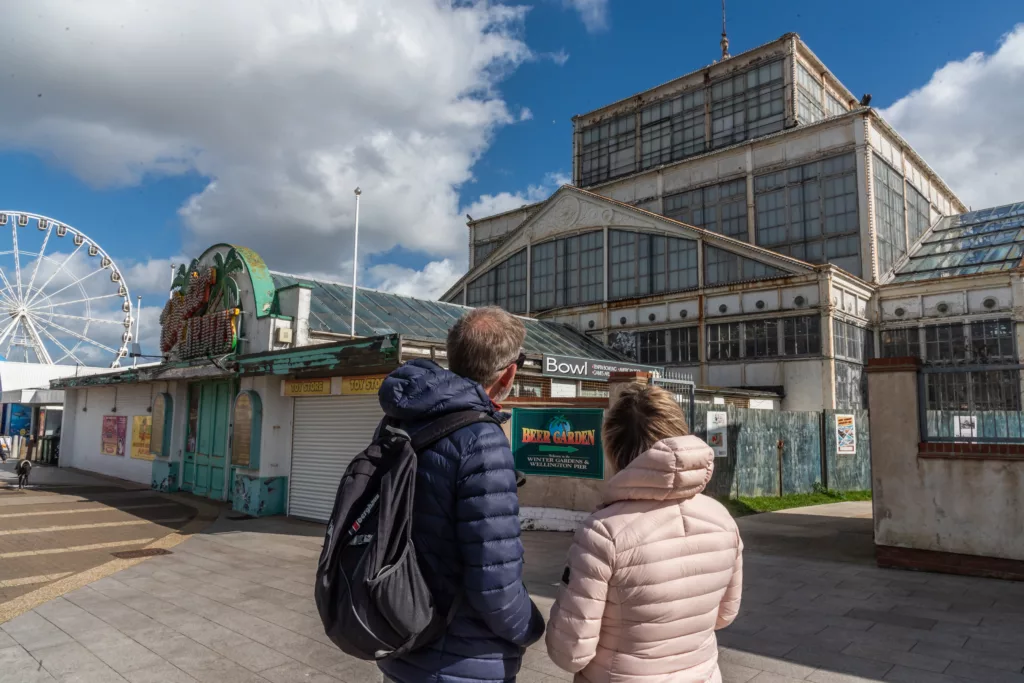 Two people looking at the Winter Gardens building in Great Yarmouth