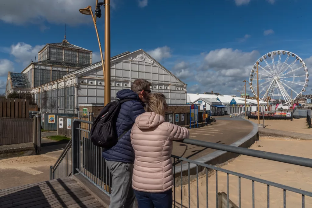 Two people looking at the Ferris wheel behind the Winter Gardens, Great Yarmouth