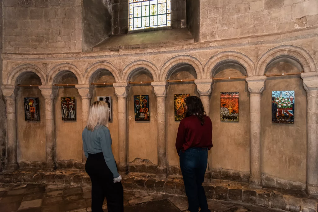 Two women looking at paintings inside Norwich Cathedral