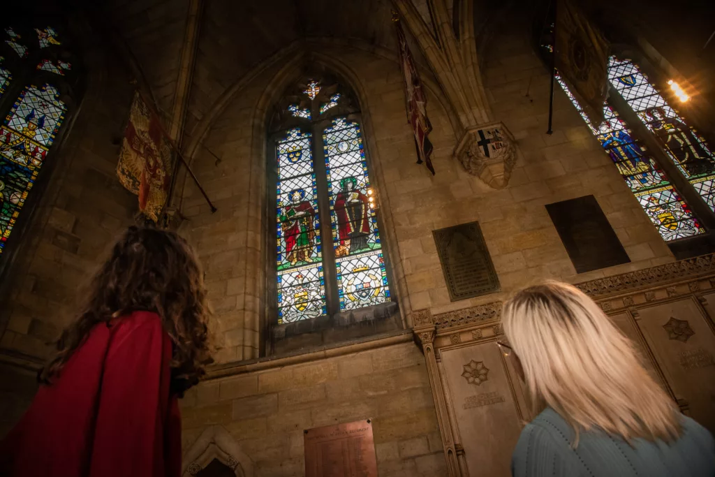 Two women looking at stained glass windows in Norwich Cathedral