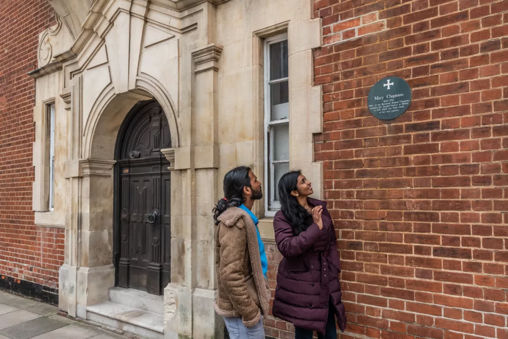 Two people reading a plaque to Mary Chapman