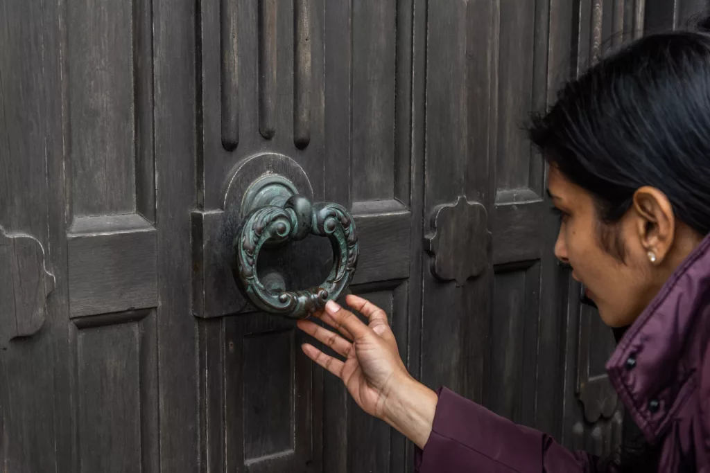 A woman looking closely at the detailing on a door handle