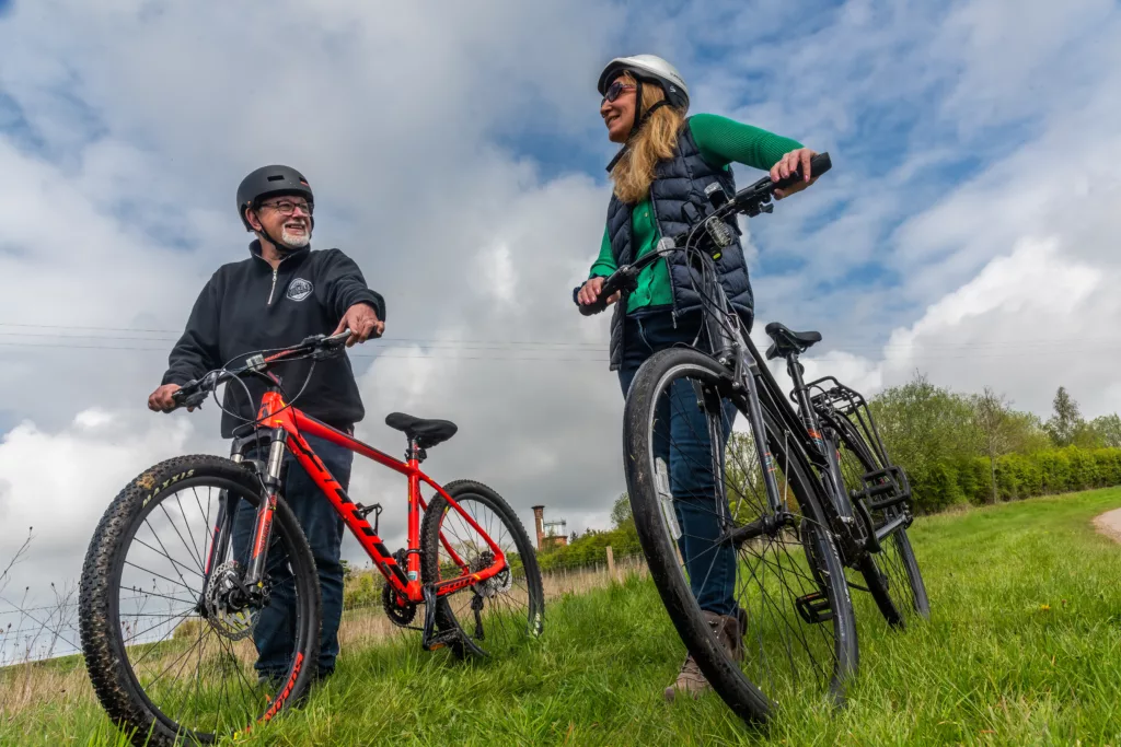 Two people standing next to their bikes