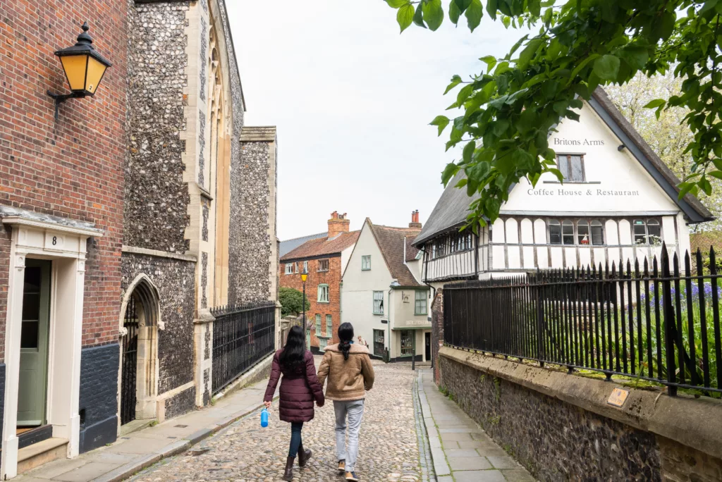 Two people walking down the cobbled street, Elm Hill, Norwich