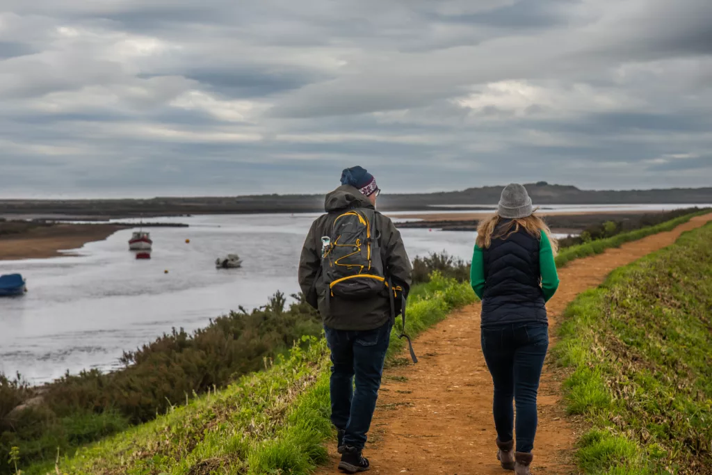 Two people walking on a dirt path next to Burn River