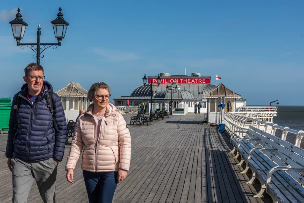 Two people walking away from the Pavilion Theatre at Cromer Pier