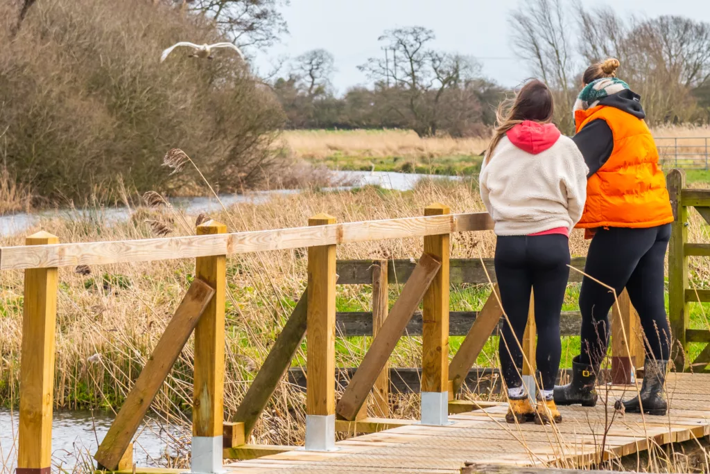 Two people on a bridge over the North Walsham and Dilham Canal