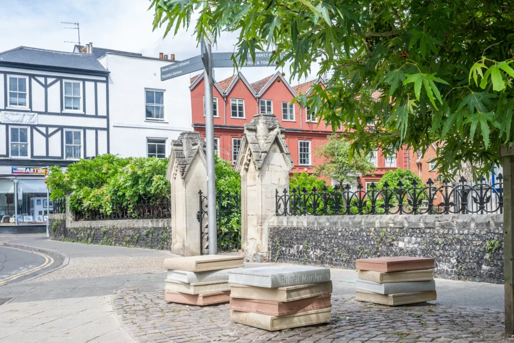 Three seats resembling stacks of four books outside St Giles-on-the-Hill, Norwich